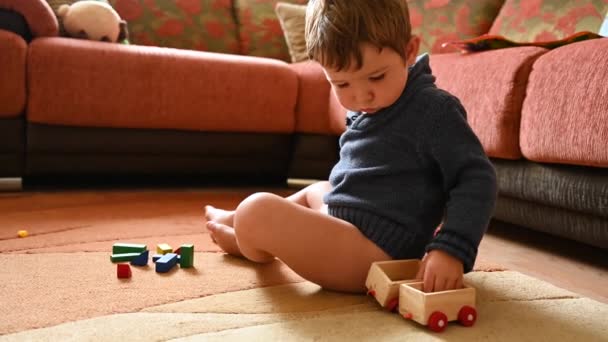 Child playing with toys while sitting on the carpet — Stock Video