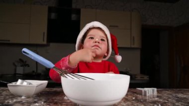 Noel şapkalı bir çocuk yemek pişiriyor. Yüksek kaliteli video