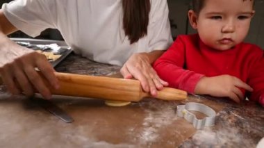 Anne ve bebek hamuru dışarı atıyor. Mutfakta yemek pişirmek.