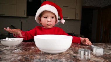Mutfakta Noel şapkası takan bir çocuk. Yüksek kaliteli video