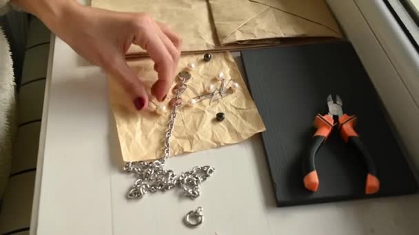 Meisje maakt sieraden met haar handen. Hoge kwaliteit video — Stockvideo