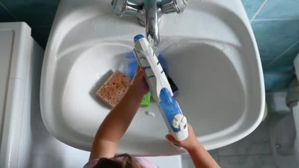 L'enfant tire de l'eau dans un pistolet à eau. Vidéo de haute qualité — Video
