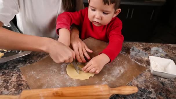 Mutter und Baby rollen den Teig aus. Kochen in der Küche — Stockvideo