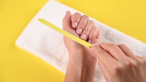 Fille scie des ongles sur un fond jaune. Vidéo de haute qualité — Video