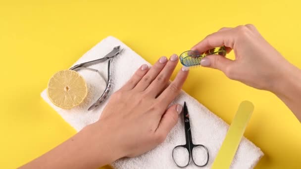 Fille scie des ongles sur un fond jaune. Vidéo de haute qualité — Video