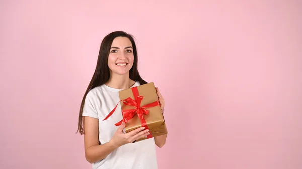 Jonge Vrouw Met Een Glimlachend Cadeau Een Roze Achtergrond Hoge — Stockfoto