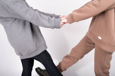 İki genç kadın kıyafetlerini, doğal kumaştan örülmüş giysilerini, modaya uygun kıyafetlerini sergiliyor..