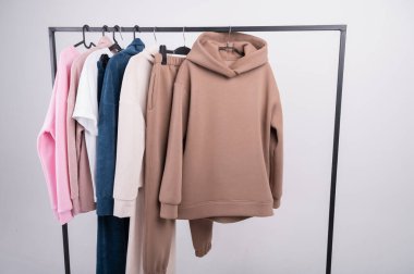 Moda turuncu kapüşonlu kapüşonlu kazak yakın çekim ve askı arka planında kahverengi gömlek. Yüksek kalite fotoğraf