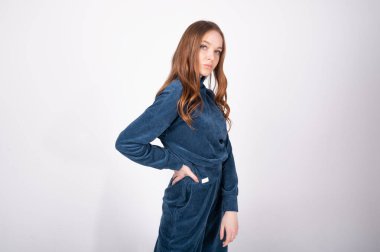 Mavi takım elbiseli genç bir kız, izole bir arka planda.