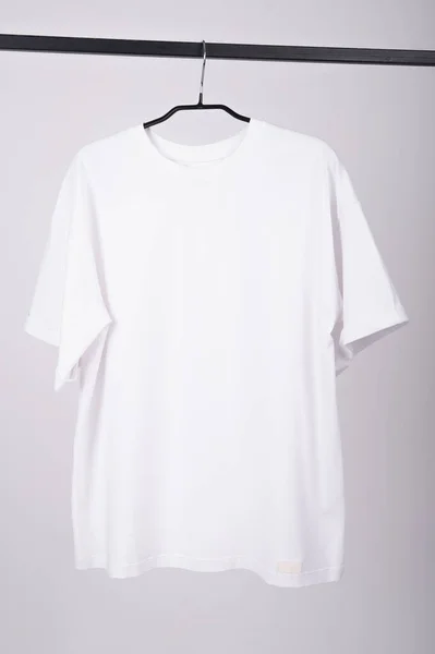 White T-shirt hangs on a hanger