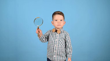 Mavi arka planda çocuk ve büyüteç
