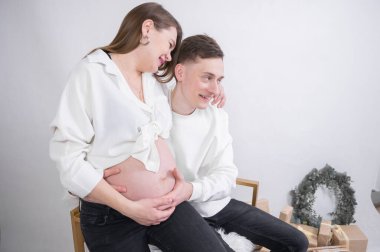 Genç baba müstakbel annenin karnına tutunuyor. 