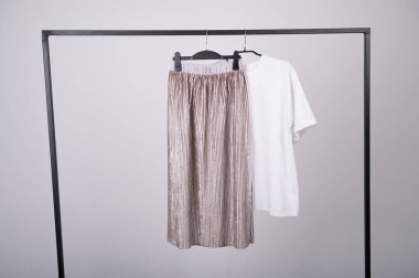 Beyaz bir tişört ve pileli etekle kadın gardırobu. Moda blogu, web sitesi, sosyal medya. Bahar elbisesi konsepti. 