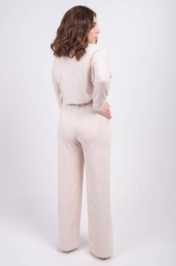 Bej renkli takım elbise, bluz ve pantolon giymiş şık giyinen genç bir kadının tam boy izole edilmiş portresi. Güzel kadın katmanlı kıyafet. Günlük kıyafetler. - Evet. Yüksek kalite fotoğraf