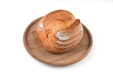 İzole bir zeminde, ahşap bir tahtanın üzerinde yuvarlak ev yapımı ekmek. Yüksek kalite fotoğraf