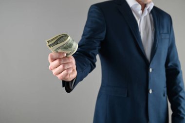 Takım elbiseli bir adam elinde para tutar. Yüksek kalite fotoğraf