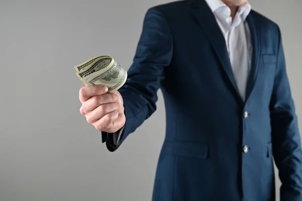 a man in a suit holds money in his hands . High quality photo