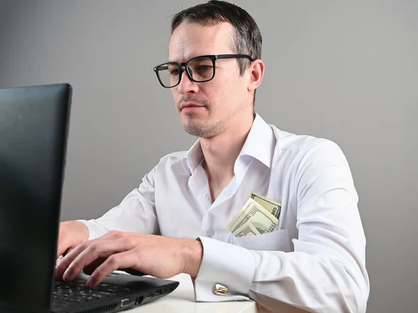 A man sitting at a computer makes money. High quality photo