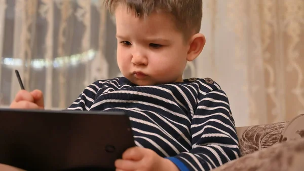 Child draws on a graphics tablet . High quality photo