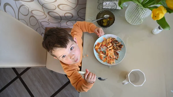 The child takes food at the table, top view . High quality photo