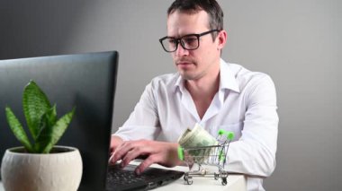 Bilgisayarın başında oturan bir adam internetten alışveriş yapıyor.