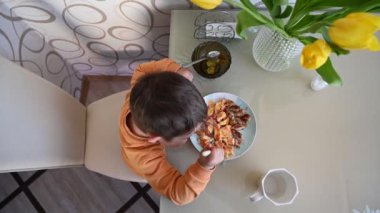 Çocuk masada yemek yiyor, manzarası çok güzel. Yüksek kaliteli video