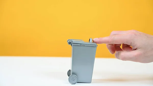 gray trash can on yellow background