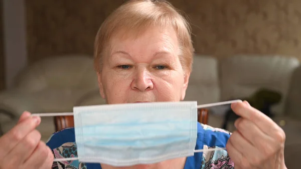 Die Ältere Kaukasische Frau Zieht Die Medizinische Schutzmaske Über Ihrem — Stockfoto