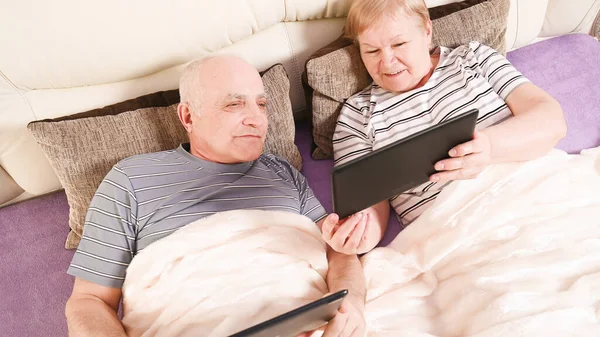 Modern elderly couple in bed.