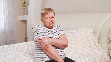 Kollarında ağrı olan yaşlı bir kadın..