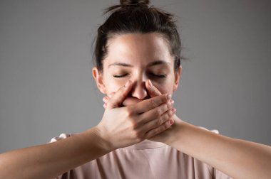 Kadın elleriyle ağzını kapatıyor..