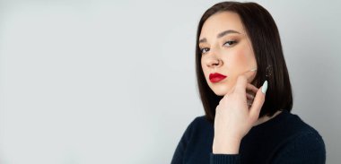 Burnunda piercing olan güzel bir esmerin portresi. İzole bir arkaplanda.