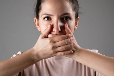 Kadın elleriyle ağzını kapatıyor..