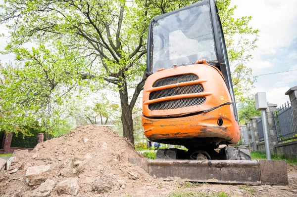 Mini excavator in orange color. construction equipment rental.