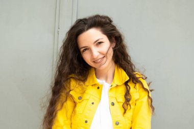 Gri arka planda güzel kıvırcık kız. 