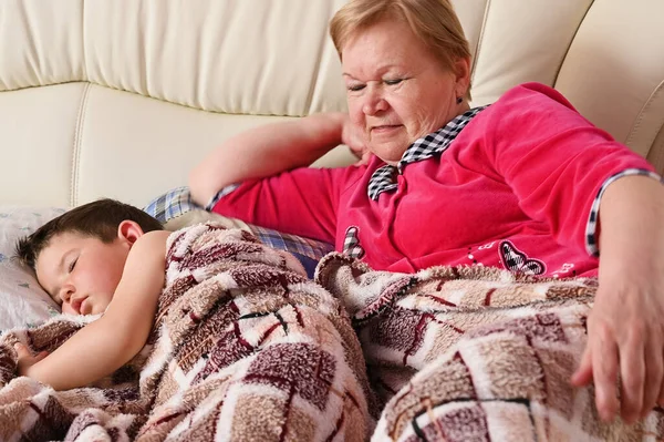 Babička a dítě leží na posteli. — Stock fotografie