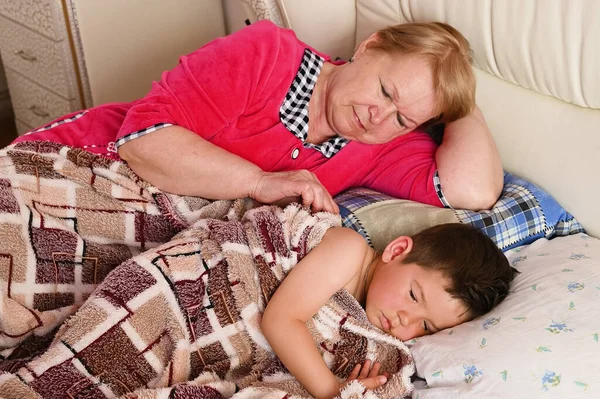 Grandmother puts the child to bed — Stock Photo, Image