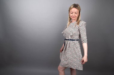 Gri arka planda yaz elbisesi giyen kadın.. 