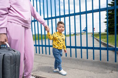 Anne ve çocuk uçağa gidiyor. 