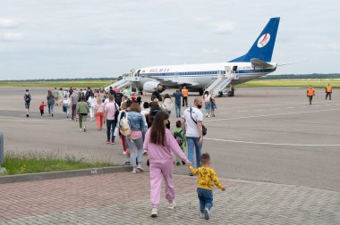 Minsk, Belarus - 5 Haziran 2021: Anne ve çocuk uçağa biniyor