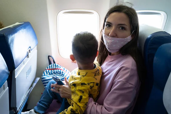 Мама з немовлям на колінах у літаку. — стокове фото
