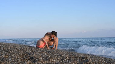 Annem deniz kenarında bir çocukla tatilde.. 