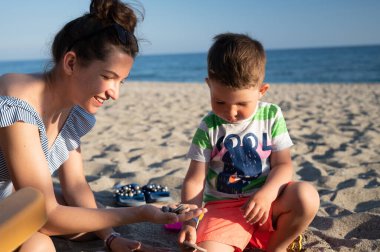 Anne oğluyla sahilde sohbet ediyor. 