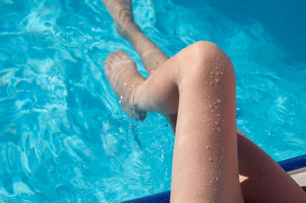 Mujer joven enjuagándose los pies en la piscina — Foto de Stock