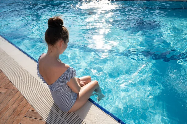 Mujer joven enjuagándose los pies en la piscina — Foto de Stock