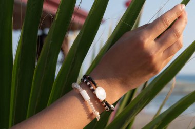 Tırnaklarında renkli desenler olan kadın elleri. 2020 tırnak rengi trendi. Üst Manzara. Mesaj için yer. Doğa konsepti. Yeşil bitki. Yüksek kalite fotoğraf