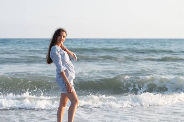 Akdeniz 'de rüzgârlı bir günde dalgalı denizle ufukta tek başına duran bir kadın. Yüksek kalite fotoğraf