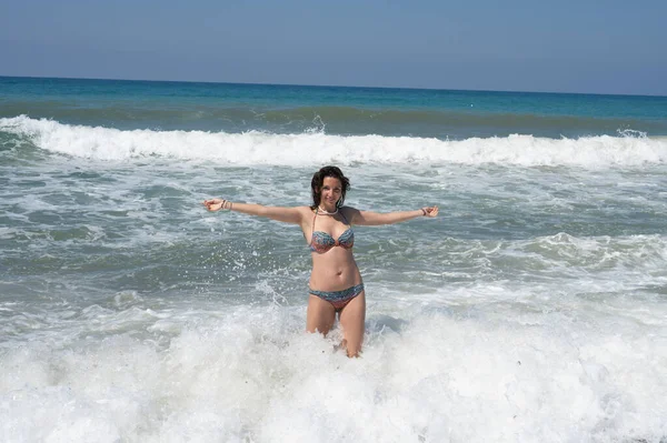 穿着白衬衫的年轻女子在一个奇异的热带岛屿上的海浪中沐浴在泡沫中 高质量的照片 — 图库照片