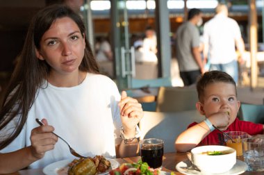 Genç anne çocuğuyla birlikte bir restoranda yemek yiyor..