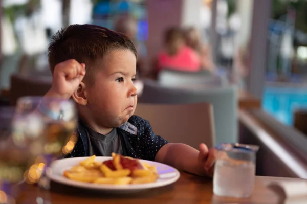 Criança Está Sentada Sozinha Num Restaurante Imagens De Bancos De Imagens Sem Royalties